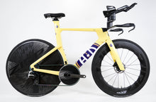 Load image into Gallery viewer, A yellow and black triathlon bicycle with a flat drop handlebar, deep section wheels, and a blue and gold frame decal, photographed against a clean white studio background.
